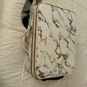 has attachable strap, organizers, holds makeup brushes. many zips & compartments